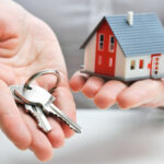A Person Having A Homekit In One Hand A Key In Other Hand Representing Mortgage Loan Concept.