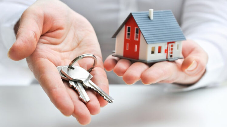 A Person Having A Homekit In One Hand A Key In Other Hand Representing Mortgage Loan Concept.