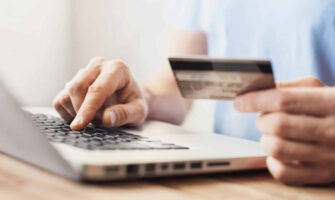 A Man Typing His Credit Card's Number In His Laptop.