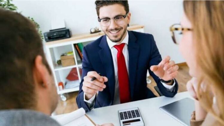 A Smiling Bank Employee Explaining About Loan Agreements To His Customers.