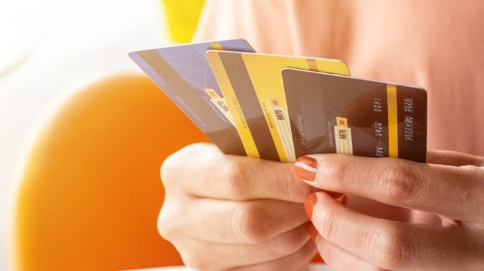 A Woman Hold A Collection Of Credit Cards In Her Hand.